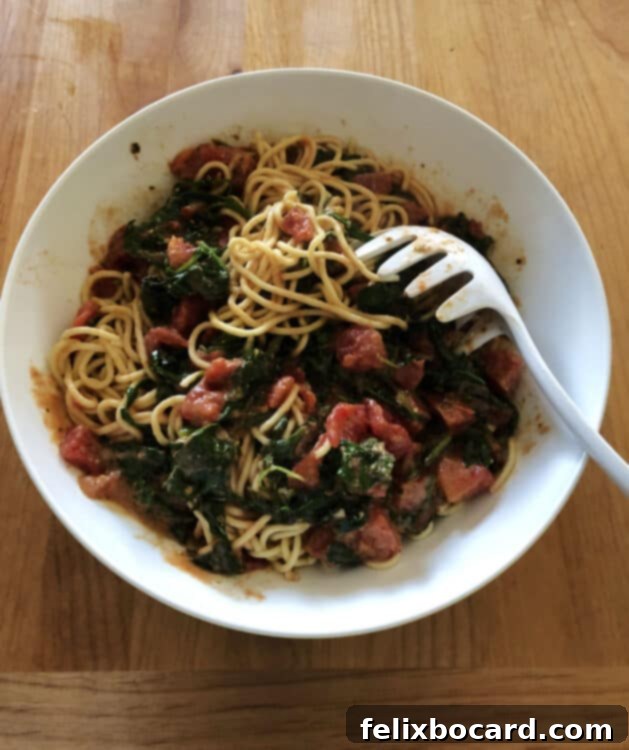 Sauce and pasta in a white bowl, partially mixed, showcasing the vibrant colors of the freshly prepared dish.