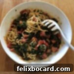 A serving bowl of easy weeknight pasta and sauce, garnished with fresh herbs and cheese.