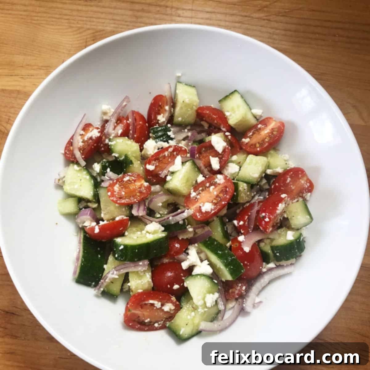Greek cucumber salad in a white serving bowl