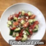 Greek cucumber salad in a white serving bowl