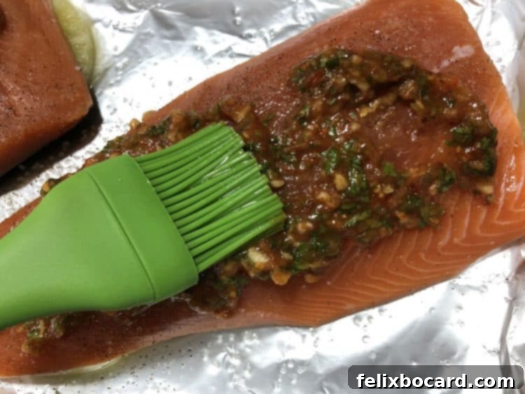 Spreading savory-sweet sauce over raw salmon fillet