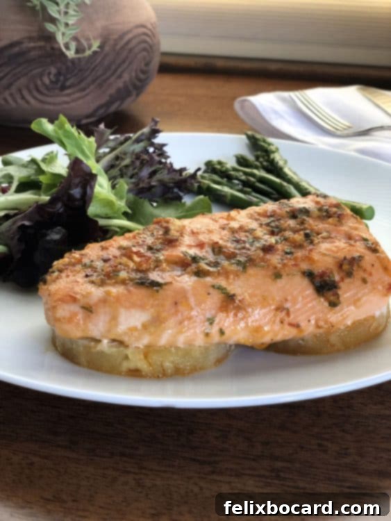 Perfectly cooked Baked Pineapple Salmon on a white plate with a side salad