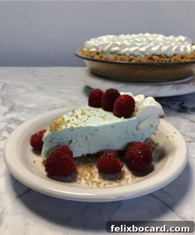 blue raspberry koolaid pie on a plate with rest of pie behind