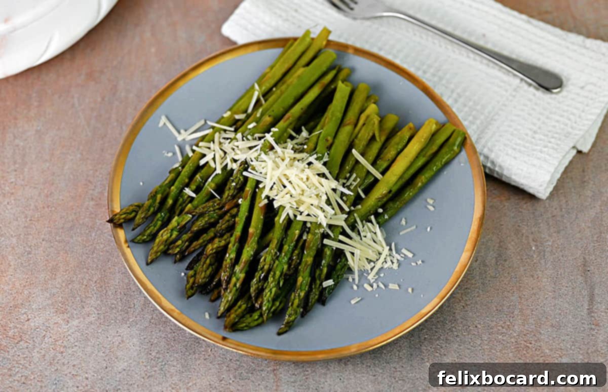 Plate of asparagus that was cooked in foil, sprinkled with shredded Parmesan cheese.