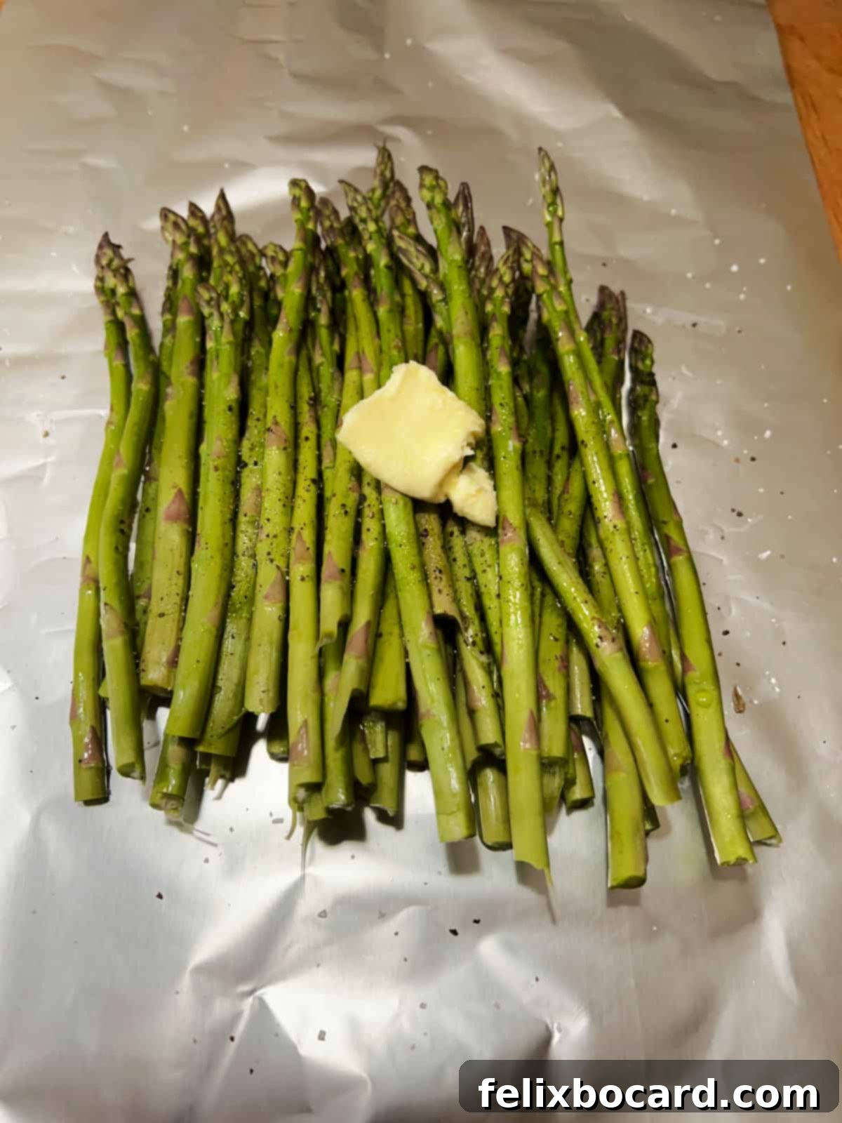 Pat of butter added to the asparagus before grilling.
