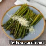 Plate of asparagus grilled in foil and garnished with Parmesan cheese.