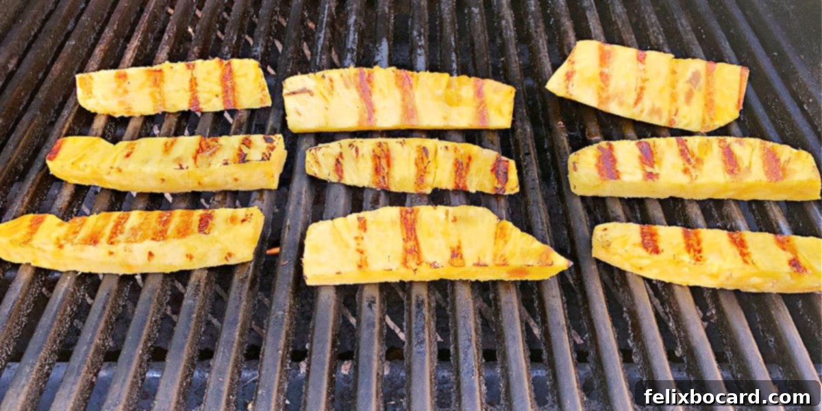 Sweet and Smoky Grilled Pineapple 2 Pineapple spears on the grill, showing perfect grill marks.