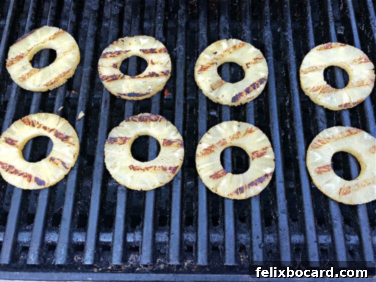 Sweet and Smoky Grilled Pineapple 4 Round slices of canned pineapple cooking on the grill grates.
