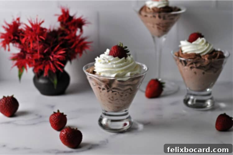 easy chocolate mousse in a glass topped with whipped cream and a strawberry