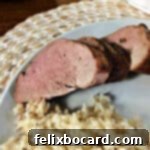 Succulent Grilled Pork Tenderloin 8 pork tenderloin slices on a white plate with rice