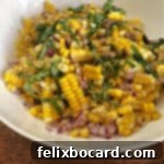 Close-up of vibrant fresh corn salad in a white bowl, garnished with basil.