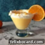 Orange Creamsicle Cocktail in a martini glass garnished with whipped cream