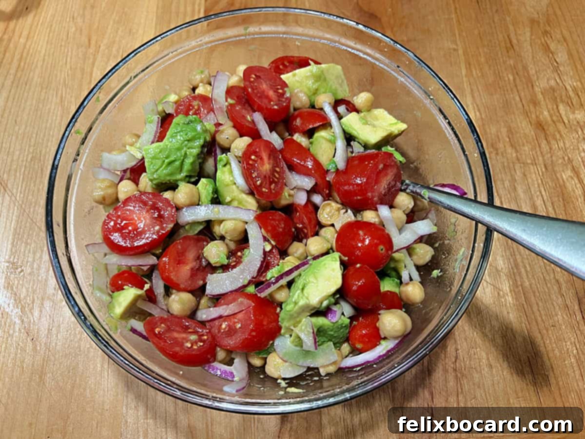 A final shot of the completely mixed chickpea avocado salad, showcasing all ingredients harmoniously combined, ready for enjoyment.