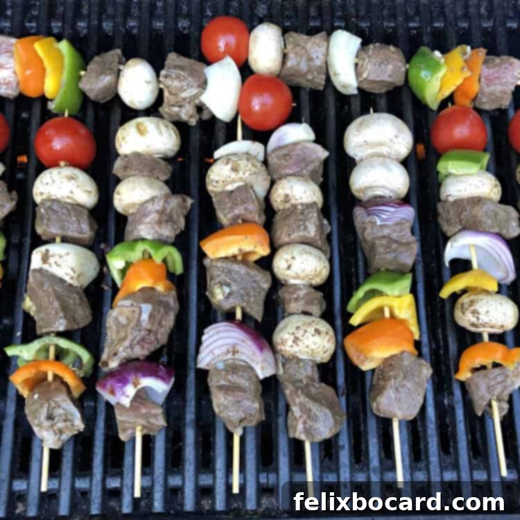Succulent beef and colorful vegetable kabobs cooking on a hot grill, showing perfect char marks.