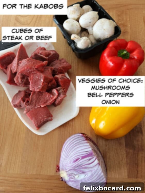 Main ingredients for beef kabobs: cubed sirloin steak and a colorful assortment of bell peppers, onions, and mushrooms ready for skewering.