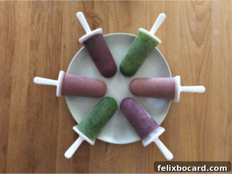 A circular arrangement of six homemade smoothie popsicles on a white plate, showcasing their inviting appearance.