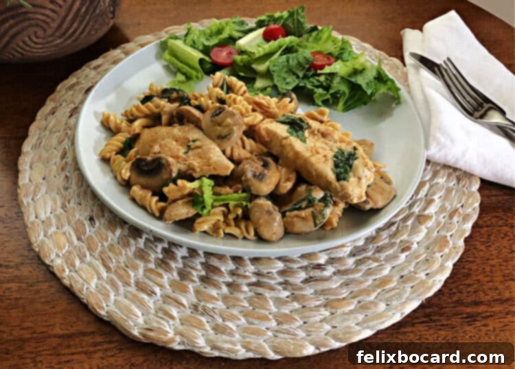 sun dried tomato pesto chicken on a plate with a side salad