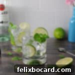 Bacardi mojito in a glass with ice, mint and limes. a second mojito is behind the first.