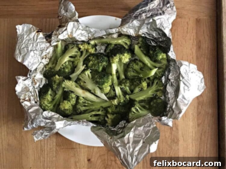 Grilled broccoli in a foil packet served on a white plate