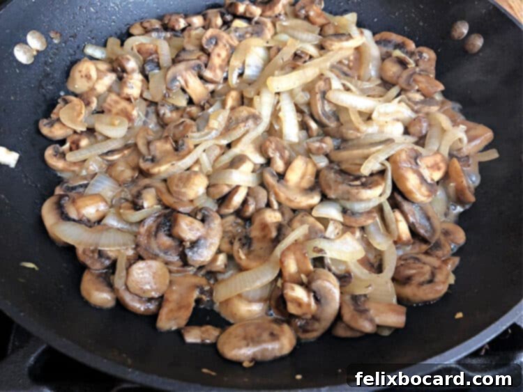 Delicious skillet of golden brown sautéed mushrooms and onions ready to serve, garnished with fresh parsley.