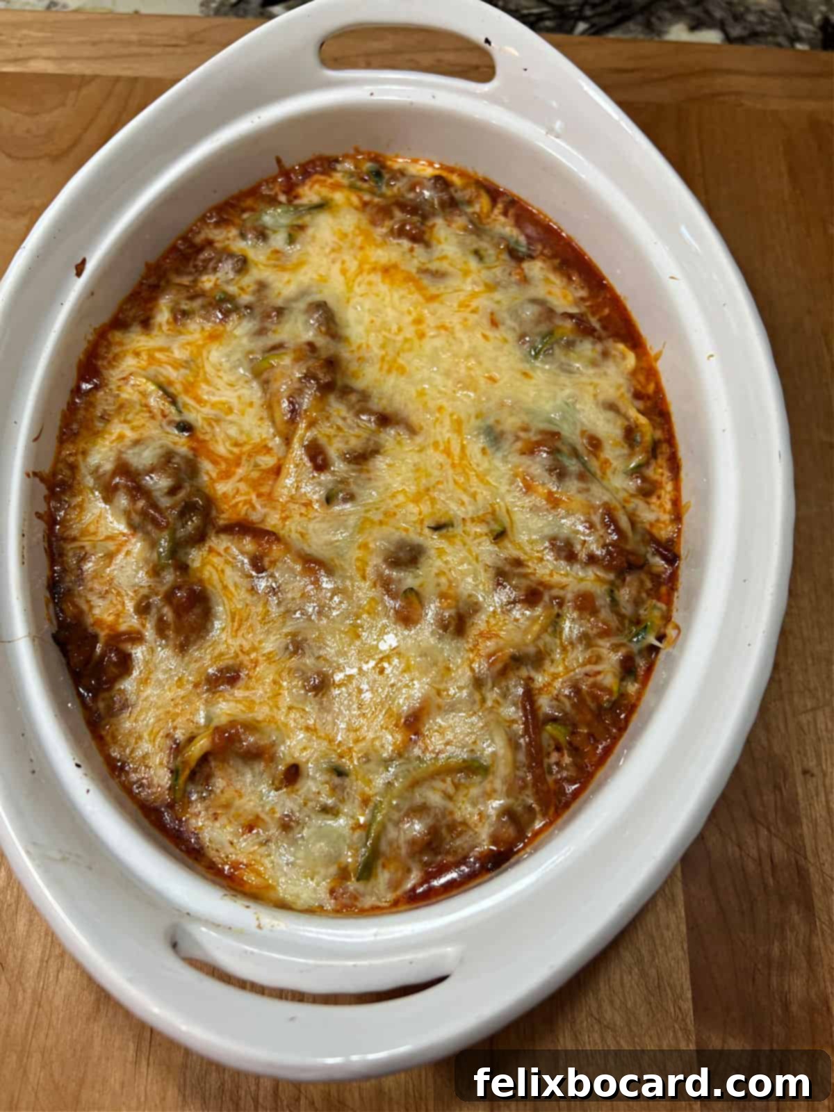 Baked spaghetti casserole fresh out of the oven, showing perfectly melted and slightly browned cheese on top.