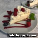 keto cheesecake garnished with berries and fruit sauce