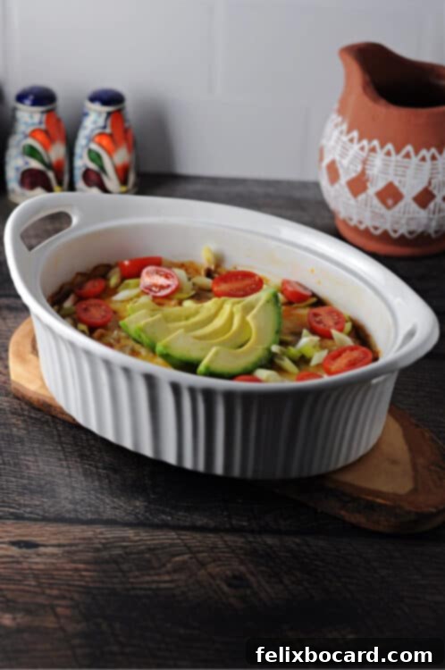 Close-up of a bubbling Keto Taco Casserole in an oval dish, freshly baked and ready to serve, showcasing melted cheese and seasoned ground beef.