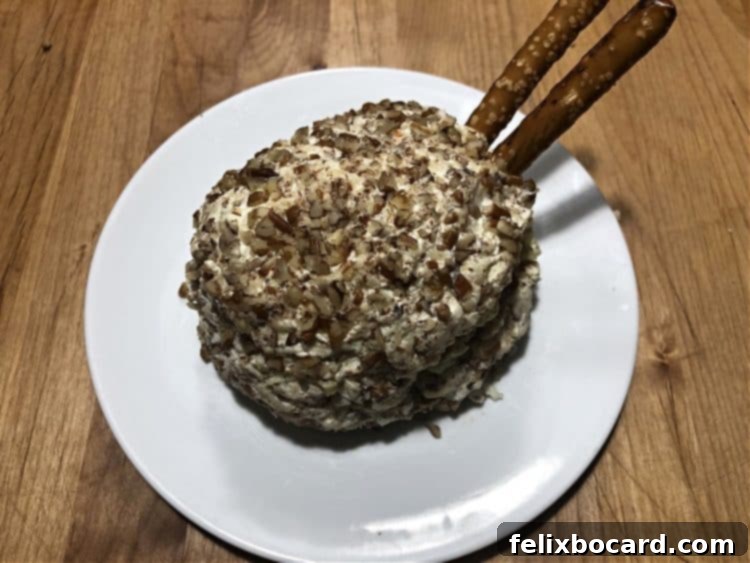 Beginning the insertion of pretzel rods into the cheese ball to form the turkey's fan-shaped tail.