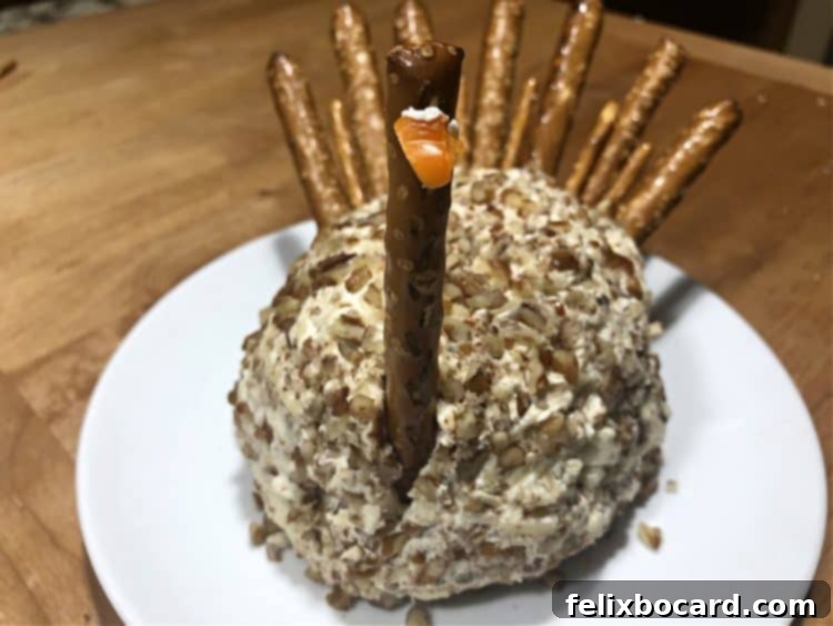 Attaching a small piece of bell pepper to the pretzel rod as the turkey's beak.