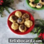 7 thumbprint cookies on a small red plate, with an assotment of fillings: brown sugar icing, jam and Nutella