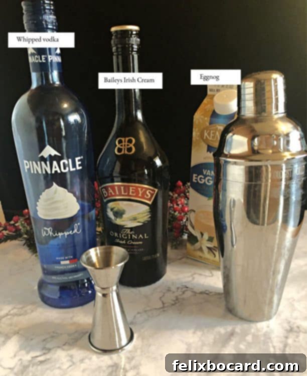 A collection of ingredients for the Baileys Eggnog Cocktail, including bottles of Baileys Irish Cream, eggnog, and whipped vodka, arranged on a festive background.