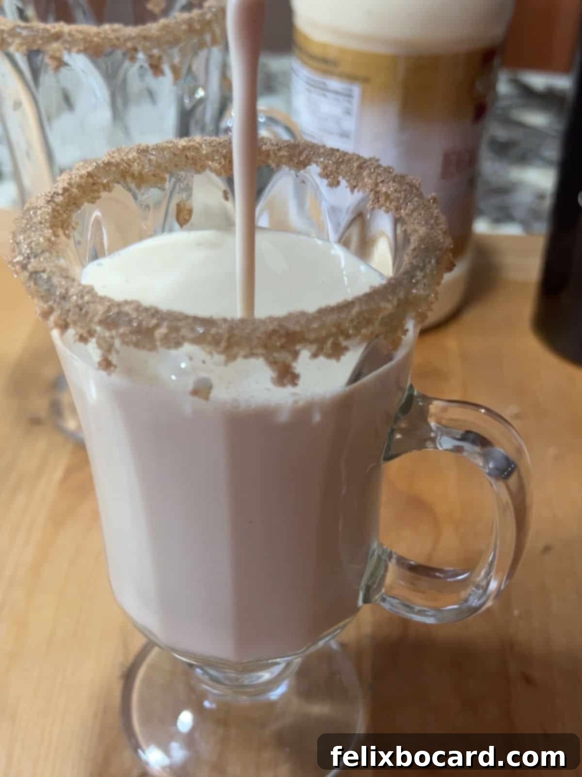 A delicious Eggnog Baileys cocktail being strained from a shaker into a prepared chilled cocktail glass.