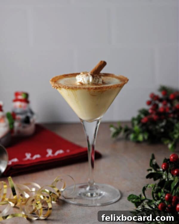 A beautifully arranged Eggnog Baileys cocktail, garnished with nutmeg, whipped cream, and a cinnamon stick, surrounded by festive Christmas decor.