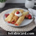 Three fruit crepes on a plate with whipped cream and fresh berries