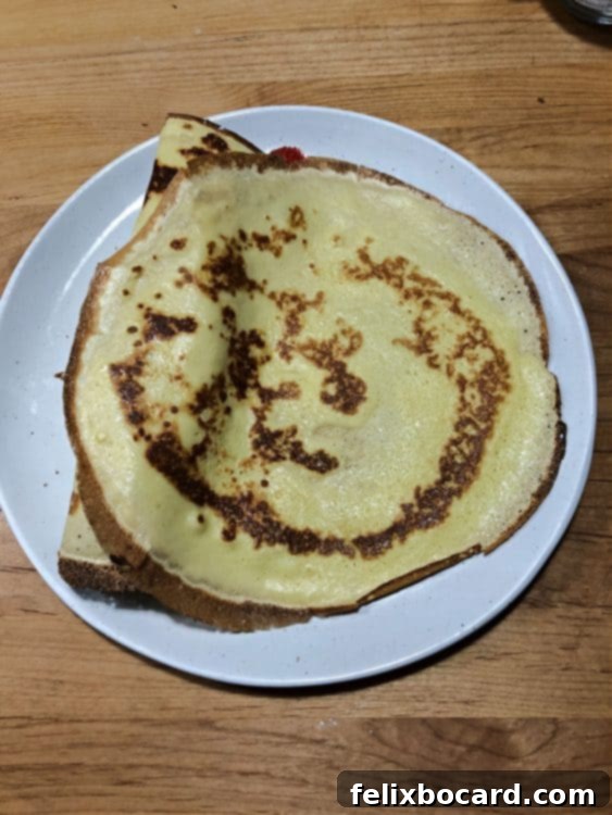 Unfilled crepe resting on a plate, ready for its delicious fruit filling.