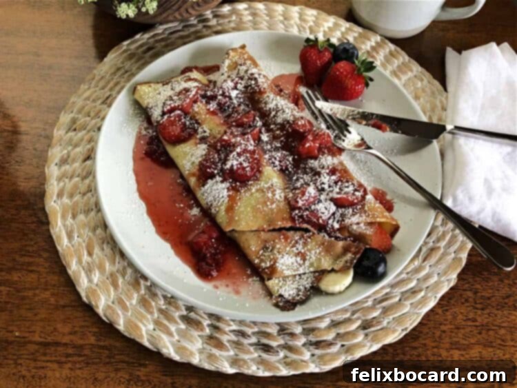 A beautifully arranged plate of fruit crepes, garnished with fresh fruit and ready to be savored.