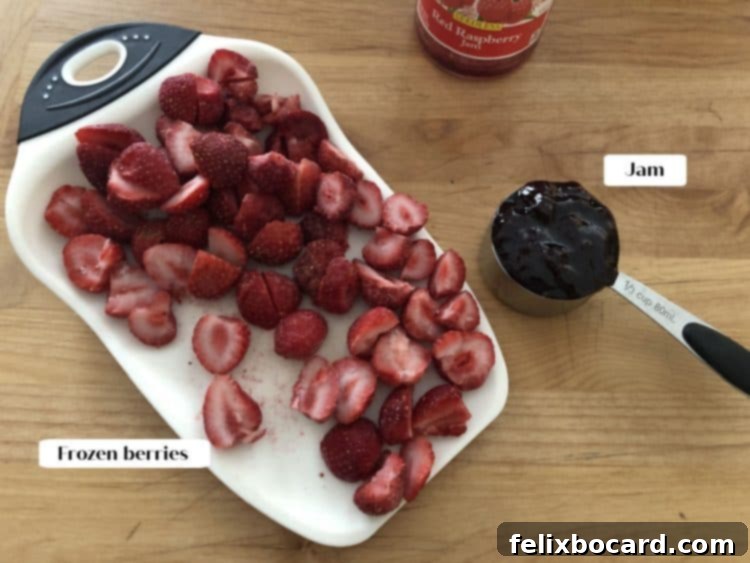 Simple Frozen Berry Sauce 3 Close-up of the two simple ingredients: a bag of frozen berries and a jar of fruit jam, laid out on a rustic cutting board.