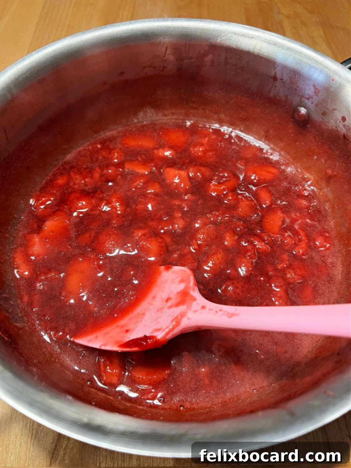 Simple Frozen Berry Sauce 5 Close-up of the freshly cooked, glistening berry sauce resting in the saucepan after cooking.