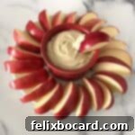 greek yogurt with peanut butter dip surrounded by apple slices