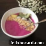 dragon fruit smoothie bowl garnished with toasted coconut and kiwi