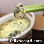 keto spinach artichoke dip on a celery stick