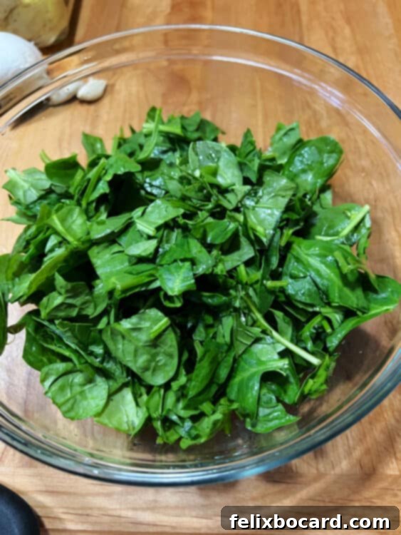 A vibrant pile of fresh spinach leaves, ready for preparation.
