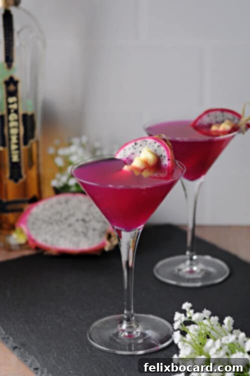 Two dragon fruit martini cocktails, garnished with fresh fruit, ready to be served.