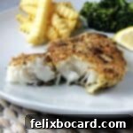 Potato crusted cod on a white plate.