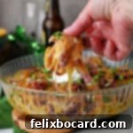 Hand holding some Irish nachos, just ready to be eaten!