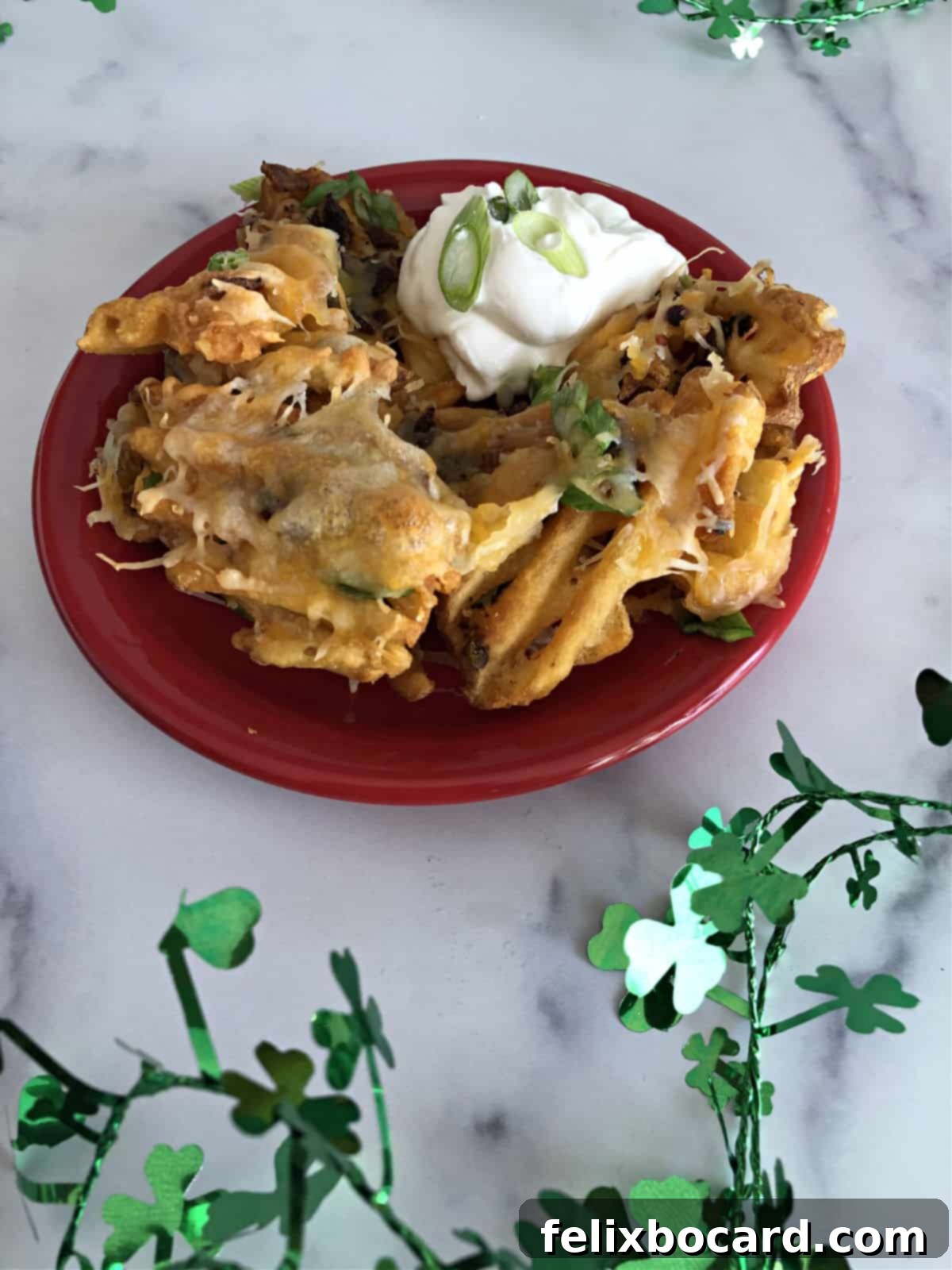 Plate of Irish Nachos with sour cream, ready to eat.