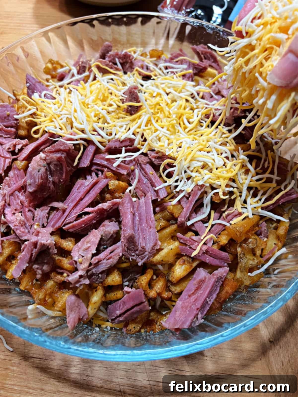 Layering corned beef and cheese in the dish to make Irish Nachos.