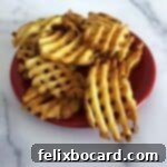 air fried waffle fries on a small red plate