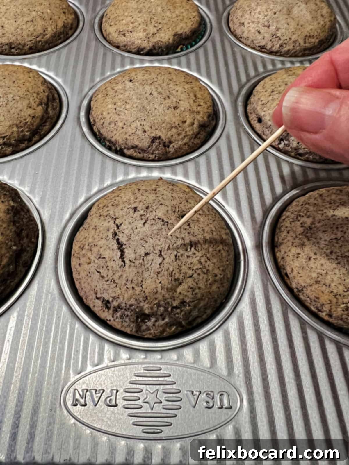 A toothpick being inserted into a cupcake to check for doneness during baking.