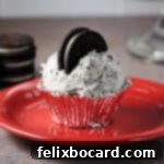 Cupcake with Oreo Buttercream frosting on a red plate.